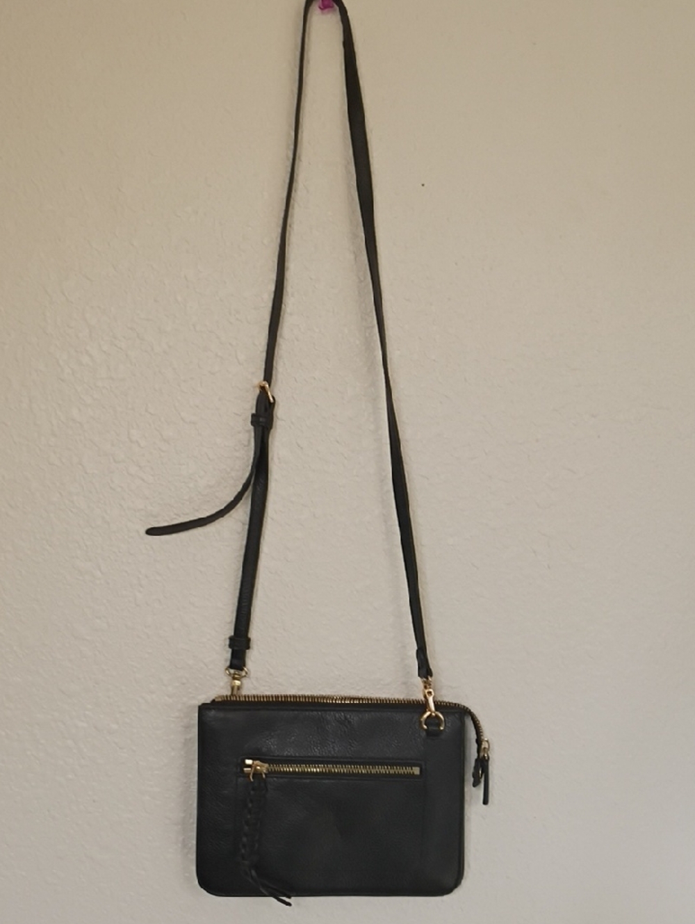 Black Crossbody Bag with Gold Zipper Accents and Adjustable Strap
